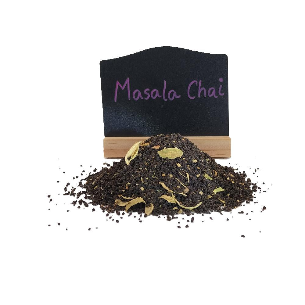 Loose leaf masala chai tea with whole spices and with a chalk board showing the tea is Masala Chai