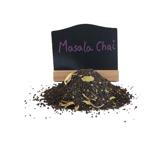 Loose leaf masala chai tea with whole spices and with a chalk board showing the tea is Masala Chai